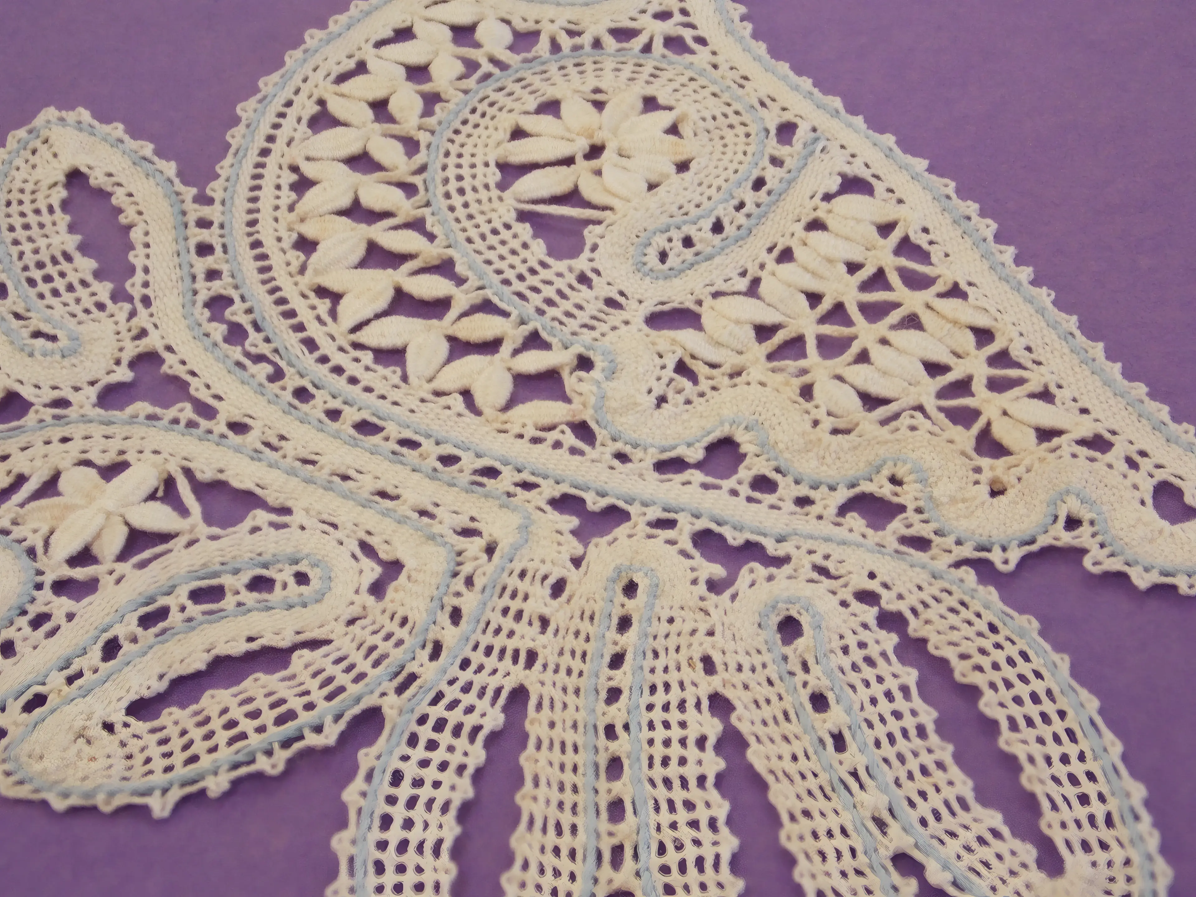Dentelle aux fuseaux et broderie hardanger — un oiseau, de près